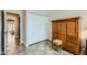 Bedroom area with closet and wood cabinet and decorative stool on light-colored tile floor at 945 N Pasadena -- # 52, Mesa, AZ 85201