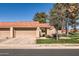 Home exterior showcases tan stucco, red-tiled roof, and a tidy front lawn with mature trees at 945 N Pasadena -- # 52, Mesa, AZ 85201