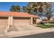 Exterior view of a tan home with a red tile roof, garage, driveway and tidy front lawn at 945 N Pasadena -- # 52, Mesa, AZ 85201