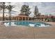 Community pool with a covered patio, lounge chairs and palm trees at 945 N Pasadena -- # 52, Mesa, AZ 85201