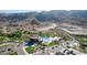 Aerial view of community clubhouse with pool surrounded by desert landscaping and vacant lots at 9814 S 11Th St, Phoenix, AZ 85042