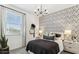 Well-lit bedroom featuring patterned wallpaper, a sleek chandelier, and stylish bedside decor at 9814 S 11Th St, Phoenix, AZ 85042