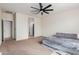 Bedroom showcases a ceiling fan, carpeted floor, and an open doorway to the bathroom at 1021 W Descanso Canyon Dr, Casa Grande, AZ 85122