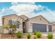 Exterior view of the home, featuring a desert landscape, a long driveway and three-car garage at 1021 W Descanso Canyon Dr, Casa Grande, AZ 85122