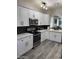 Updated kitchen featuring white cabinets, stainless steel appliances, and black subway tile backsplash at 1030 E Susan Ln, Tempe, AZ 85288