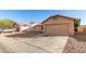 View of tan home with 2 car garage and driveway. Low maintenance landscaping with rock at 10307 W Windsor Blvd, Glendale, AZ 85307