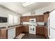 Well-equipped kitchen featuring wood cabinets, white appliances, and plenty of counter space for meal preparation at 10307 W Windsor Blvd, Glendale, AZ 85307