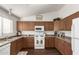 Charming kitchen with wood cabinetry, white appliances, and functional design ready for your culinary creations at 10307 W Windsor Blvd, Glendale, AZ 85307