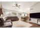 Bright open-concept living room with ample seating, a ceiling fan and easy access to kitchen and dining areas at 10307 W Windsor Blvd, Glendale, AZ 85307