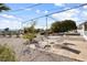 Charming backyard featuring patio, drought-tolerant landscaping, shade trees, and a relaxing outdoor seating area at 10423 W Monterosa Dr, Sun City, AZ 85351