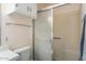 Bathroom featuring a tiled shower with a sliding door, white toilet, and a tile floor at 10423 W Monterosa Dr, Sun City, AZ 85351