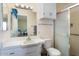 Bathroom with a tile shower, integrated sink and vanity, and a mirrored cabinet at 10423 W Monterosa Dr, Sun City, AZ 85351