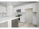 Modern kitchen featuring white cabinets, quartz counters, stainless appliances, and a large center island with a sink at 10947 W Malibu Cir, Arizona City, AZ 85123