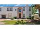 Charming two-story home featuring stucco siding, a terracotta roof, a manicured lawn, and a stylish front door at 111 W Missouri Ave # E, Phoenix, AZ 85013