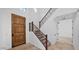 Grand foyer featuring a wooden door, tiled floors, and a staircase with custom iron railing and wood trim at 111 W Missouri Ave # E, Phoenix, AZ 85013