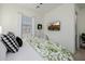 Cozy bedroom with green patterned bedding, decorative wreath and a wall-mounted TV at 11143 N Mckinney St, Surprise, AZ 85388