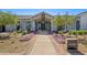 Exterior view of the welcoming Sterling Grove clubhouse entrance with beautiful landscaping at 11143 N Mckinney St, Surprise, AZ 85388