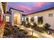 Close up on a well lit entry with a stone pathway and inviting landscaped garden in front of the home at 11143 N Mckinney St, Surprise, AZ 85388