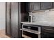 Kitchen with dark wood cabinetry, marble countertops, and stainless steel appliances at 11143 N Mckinney St, Surprise, AZ 85388