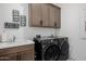 Laundry room with gray cabinets, modern washer and dryer and decorative wall decor at 11143 N Mckinney St, Surprise, AZ 85388