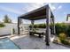 Stylish outdoor lounge area featuring a pergola, comfortable seating, and elegant striped curtains at 11143 N Mckinney St, Surprise, AZ 85388