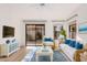 Comfortable living room with light wood floors, a ceiling fan, and sliding glass doors to the backyard at 1157 W Edgewater Dr, Gilbert, AZ 85233