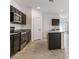 Stylish kitchen with an island, stainless steel appliances, and dark wood cabinetry at 11875 E Aster Ln, Florence, AZ 85132