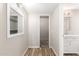 Hallway leading to the bathroom, featuring wood-look floors and a large mirror at 13234 W Desert Glen Dr, Sun City West, AZ 85375