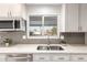 Close-up of a modern kitchen with stainless steel appliances and gray tiled backsplash at 13234 W Desert Glen Dr, Sun City West, AZ 85375