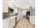 Modern kitchen with stainless steel appliances, white cabinets, and wood-look tile flooring at 13234 W Desert Glen Dr, Sun City West, AZ 85375