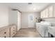 Laundry room with white cabinets, washer, dryer, and wood-look tile flooring at 13234 W Desert Glen Dr, Sun City West, AZ 85375