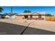 Single-story home featuring a spacious driveway and charming desert landscape at 1353 N Avoca --, Mesa, AZ 85207