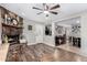 Cozy living room featuring a stone fireplace, wood floors, a ceiling fan, and open access to other rooms at 1353 N Avoca --, Mesa, AZ 85207