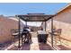 Covered patio with a black metal gazebo features a grill and seating area with paver flooring at 1353 N Avoca --, Mesa, AZ 85207