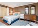 Bedroom featuring a woven headboard bed, dresser with mirrors, and a sliding glass door at 13633 N 111Th Ave, Sun City, AZ 85351