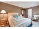 Cozy bedroom features a wicker headboard bed, brown walls, and traditional furnishings at 13633 N 111Th Ave, Sun City, AZ 85351