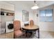 Bright breakfast nook features a round table, two chairs, a mirror and view into the laundry room with stacked washer/dryer at 13633 N 111Th Ave, Sun City, AZ 85351