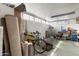 Organized garage with a bicycle, rolled carpets, and various storage solutions, illuminated by bright overhead lighting at 13633 N 111Th Ave, Sun City, AZ 85351