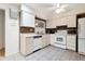 Efficient kitchen with white cabinetry, tile flooring, and matching appliances at 13633 N 111Th Ave, Sun City, AZ 85351