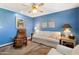 Living room with blue walls featuring sofa, reclining chair, and a ceiling fan at 13633 N 111Th Ave, Sun City, AZ 85351