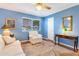 Living room with blue walls, reclining chair, writing desk and ceiling fan at 13633 N 111Th Ave, Sun City, AZ 85351