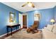 Living room featuring blue walls, reclining chair, and a writing desk at 13633 N 111Th Ave, Sun City, AZ 85351