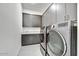 Well-equipped laundry room featuring grey cabinetry, a utility sink, and modern appliances at 14543 N Adero Canyon Dr, Fountain Hills, AZ 85268