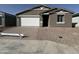 Charming single-story home with a brick driveway and a white garage door at 15752 W Beryl Ave, Waddell, AZ 85355