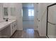 Bathroom with dual sinks, shower, and doorway to bedroom at 15762 W Cheryl Dr, Waddell, AZ 85355
