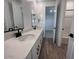 Bathroom featuring double sinks, quartz countertops, wood-look flooring, and great natural light at 15762 W Cheryl Dr, Waddell, AZ 85355
