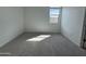 Sunlit bedroom with neutral carpet, white walls, and a window providing plenty of natural light at 15762 W Cheryl Dr, Waddell, AZ 85355