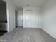 Bedroom with neutral carpet, white walls, and closet doors, with a view into the attached bathroom at 15762 W Cheryl Dr, Waddell, AZ 85355