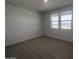 Bright, carpeted bedroom with two windows offering great natural light and neighborhood views at 15762 W Cheryl Dr, Waddell, AZ 85355