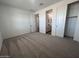 Carpeted bedroom with an ensuite bathroom, closet with sliding doors, and natural light at 15762 W Cheryl Dr, Waddell, AZ 85355